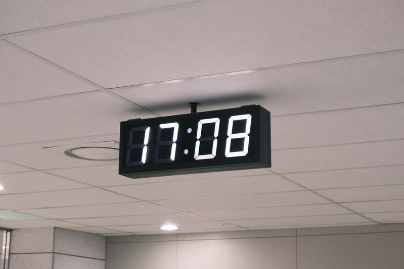Close-up of hands adjusting settings on a sleek smart clock with touchscreen interface