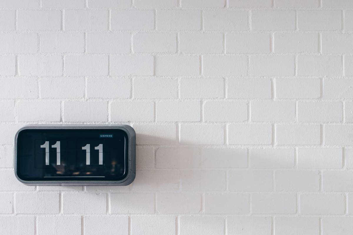 smart home display clock showing weather, calendar, and time on a bedside table